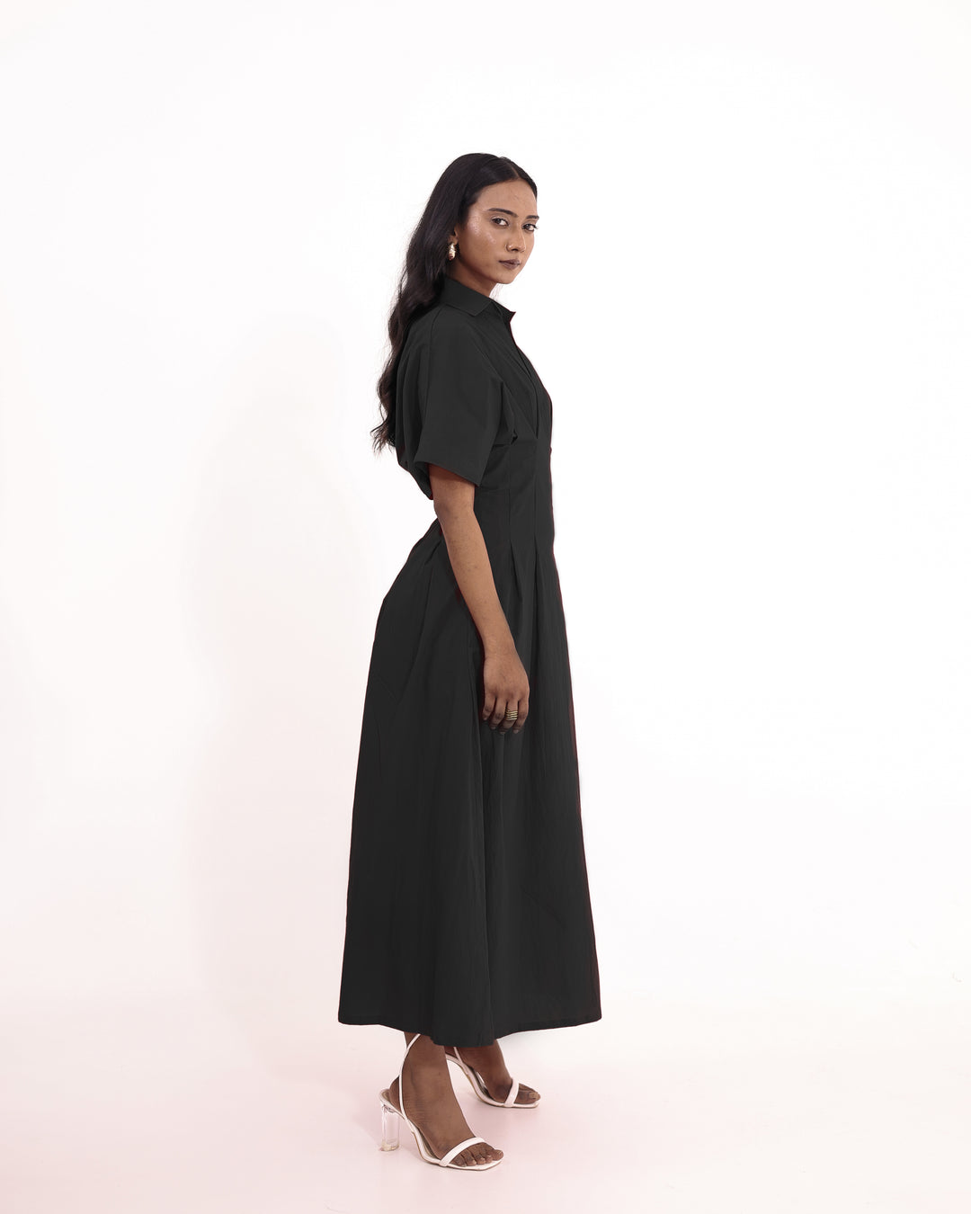 Model wearing elegant black cotton maxi dress with V-collar and pleated skirt – perfect for summer or evening wear